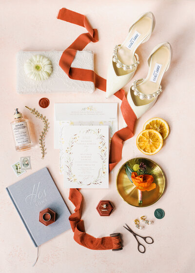 Wedding rings on top of a pink velvet ring box next to a bouquet of locally grown flowers 