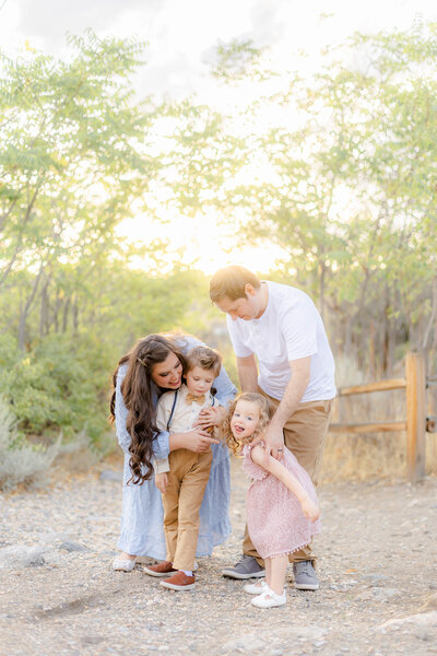 Candid family photo taken at Lambert Park in Alpine, Utah, featuring a precious moment between cute children and their parents, captured by a Utah family photographer specializing in natural and timeless portraits.