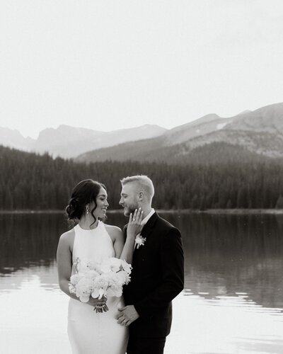 Bride and groom by alpine lake in the mountains