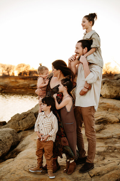 Family of five soon to be family six taking photos in a Decatur grasslands with Paula Goforth, enjoying the natural surroundings.