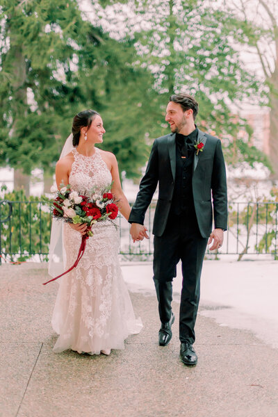 A newlywed couple holds hands while walking during their Collingswood Ballroom wedding.