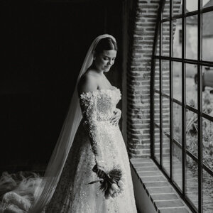 La mariée attend son futur mari pour leur first look au Domaine de Montireau dans le Perche, bouquet en main, dans un moment suspendu capté par un duo photographe vidéaste