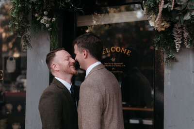 Chris and Dave standing side by side in matching suits on the rooftop of Quirk Hotel Richmond, captured in a soft, editorial wedding portrait.
