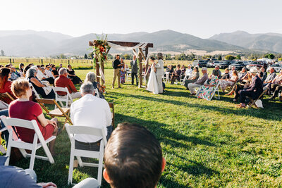 Outdoor wedding ceremony with Bitterroot Mountains in background at McVey Homestead in Victor, MT