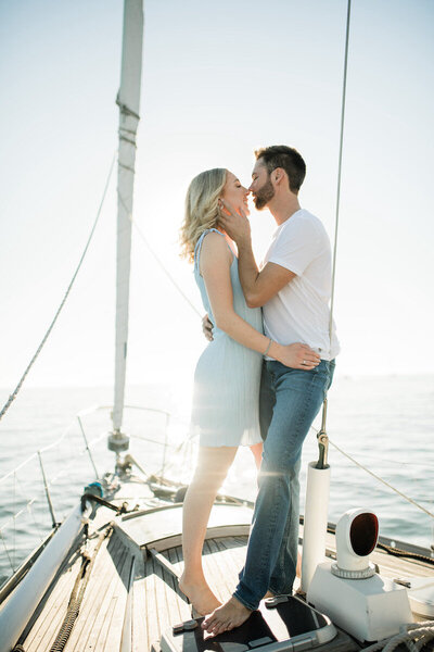 Kat and Mackenzie kiss on sailboat in California at their engagement session