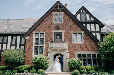 Bride and groom walk hand in hand toward The Palace Event Center in Treynor, IA. Photo by Anna Brace who specializes in Omaha NE Wedding Photography.