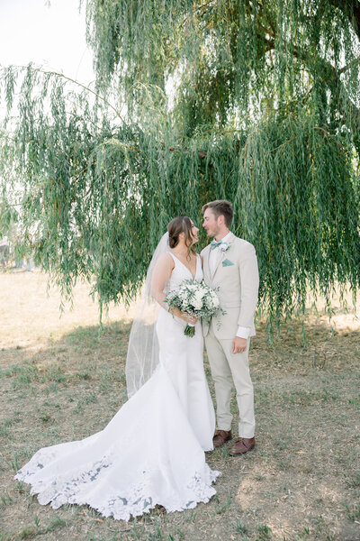 Bride and groom smiling and holding each other  taken by Spokane Wedding Photographer