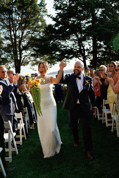Bride and groom walking down the aisle after getting married in new england