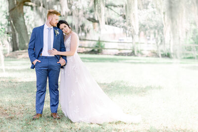 Bride snuggled into the groom’s arm as he looks lovingly down at her, capturing a quiet, intimate moment of deep connection and romance.