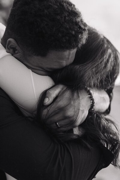 bride and groom hugging on beach