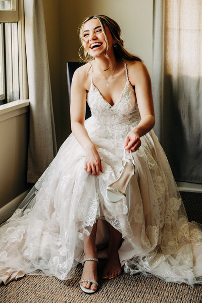 Montana bride laughing while putting on wedding shoes in Helena, MT