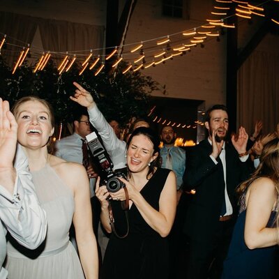 A Washington wedding photographer stands by a serene lake, her camera ready to capture timeless love stories.