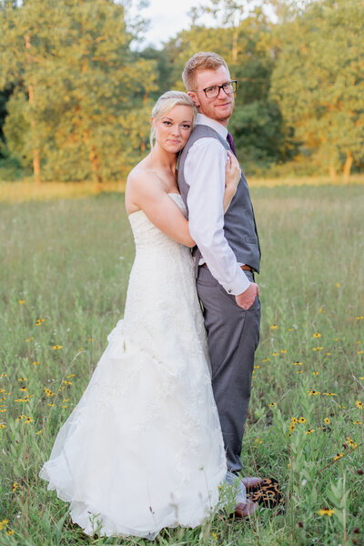 Bride hugging groom from behind