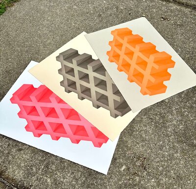 Three richly pigmented aquatint prints—coral, charcoal, and orange—laid out on concrete, showcasing vibrant tonal range.