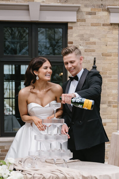 newly married couple pouring champagne tower