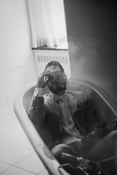 fun-black-and-white-image-of-a-groom-smoking-a-cigar-in-a-tub