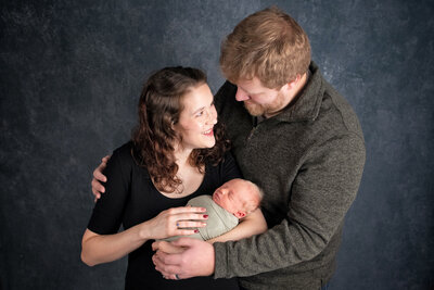 Happy couple holds newborn baby
