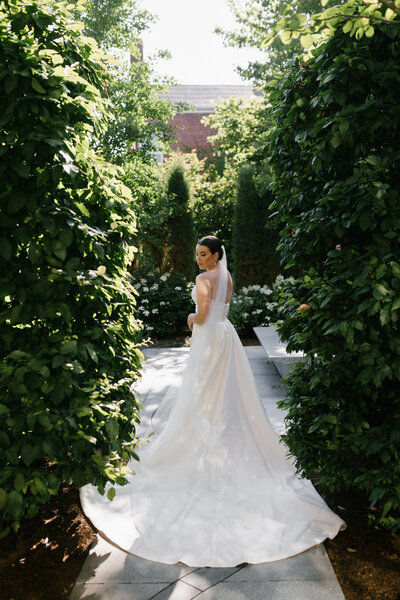 Bride in wedding dress standing in Peabody Essex Museum outdoor garden