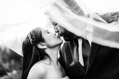 Bride and groom kissing under the bride's veil during an elopement photoshoot session in the mountains north of Seattle, WA.