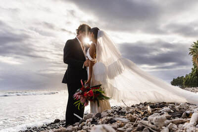 bride and groom standing on river edge