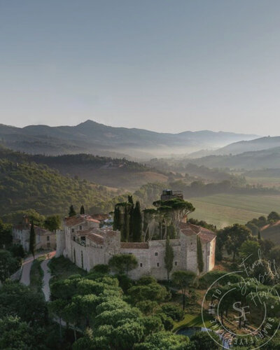 The stunning Castello di Reschio hotel in Umbria, Italy, a beautifully restored historic castle surrounded by rolling hills and lush countryside, offering an elegant retreat.