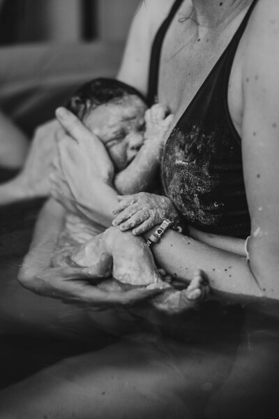 black and white image of a baby born in a water birth at home