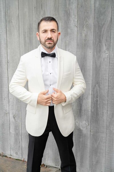 Groom in white suite jacket and black pants