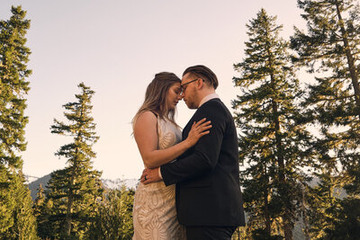 Bride and groom embrace during their mt rainier elopement surrounded by trees
