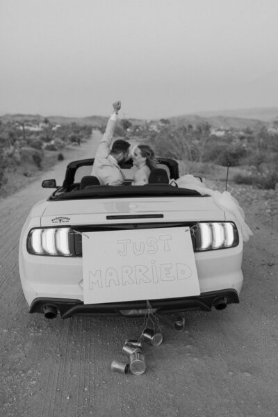 Black and white bride and groom in convertable