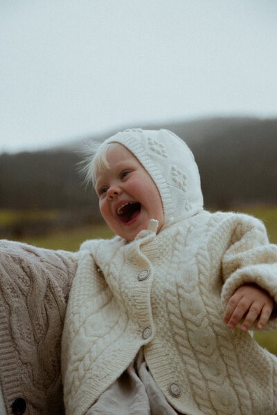 a child on a beach with wild flowers.