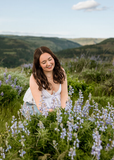 Girl sitting near wildflowers in the Columbia River Gorge.
