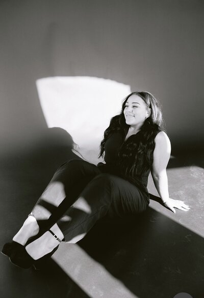 Women sitting on ground, black background