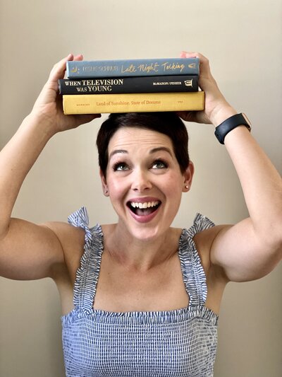 Megan Ludwick content manager with books on head