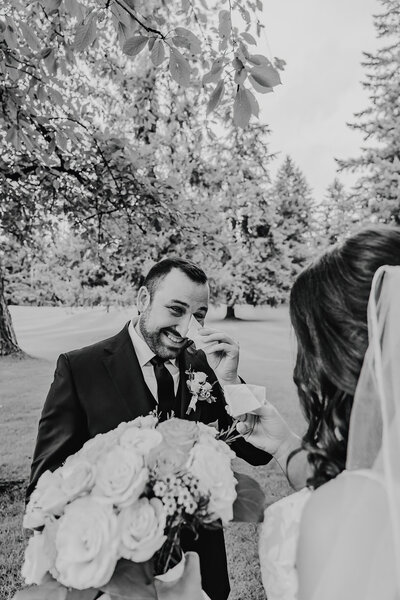 a photo of a bride standing in front of an ornate staircase holding her bouquet