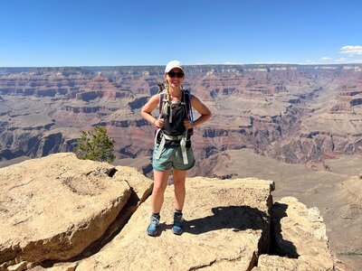 Emily standing in front of the Grand Canyon in hiking apparel