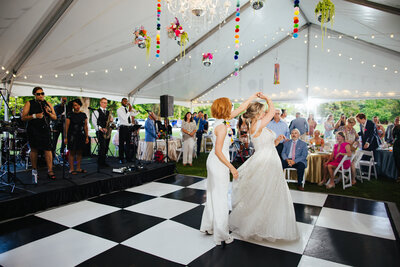 Silhouette of two men kissing with the blue sky and ocean behind them at their Micro Wedding