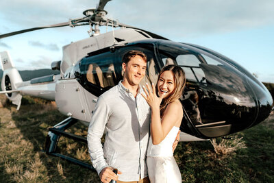 Newly engaged couple celebrating after helicopter proposal in Auckland, bride showing engagement ring, photographed by Zanthe Vorsatz.