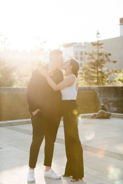 Couple kissing in downtown Bothell during sunset while taking their  engagement photos.