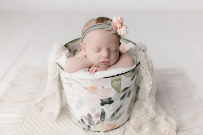 Newborn Studio Photographer with baby in a bucket prop