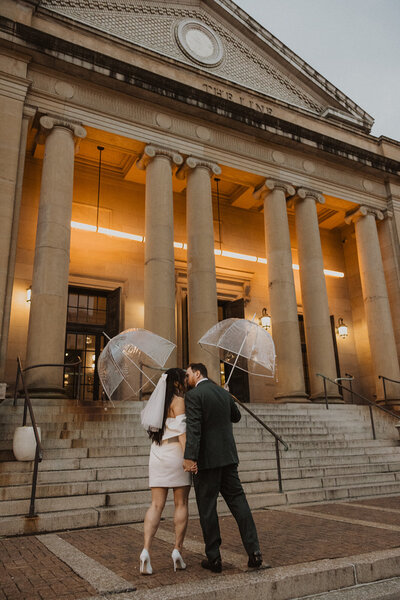Couple pose outdoors in DC elopement with umbrellas