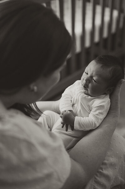 Black and white maternity portrait of a glowing mom-to-be with toddler resting on her belly in a natural outdoor setting near Charlotte, NC.