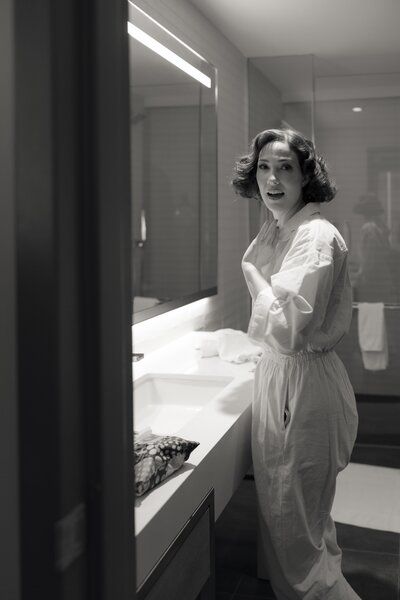 bride is getting ready and is caught with a surprise portrait in the bathroom