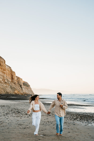 Couple running on beach by Minnesota Wedding Photographer, Kelly Friday Photography. 