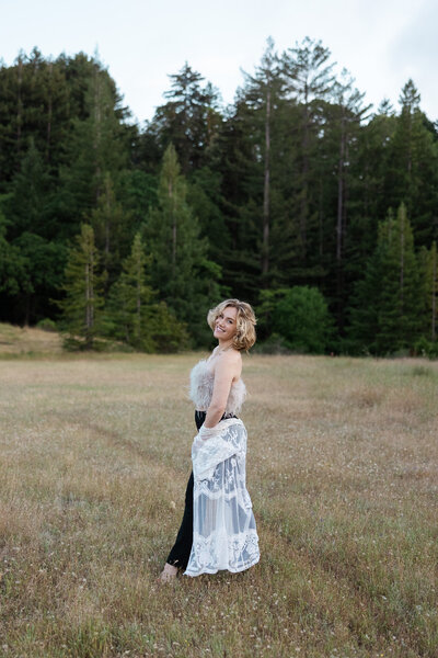 SF Bay Area brand photography shoot with a woman walking in a California field with Redwood tress in the background.