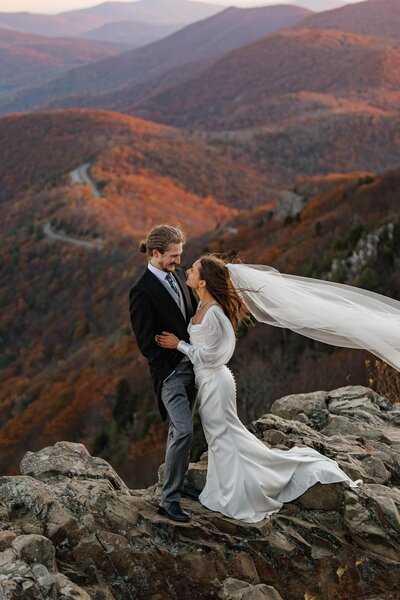 A bride and groom stand at Stonyman summit in Virginia during their elopement at sunrise