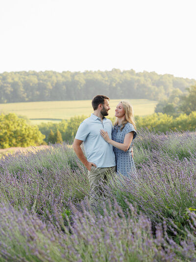 couple embracing in front of a greenhouse during fall with blooming flowers