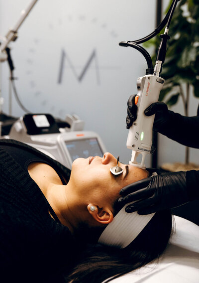 Client receiving laser facial treatment at Maxwell Aesthetics Salem, Oregon, to enhance skin tone and achieve lasting results