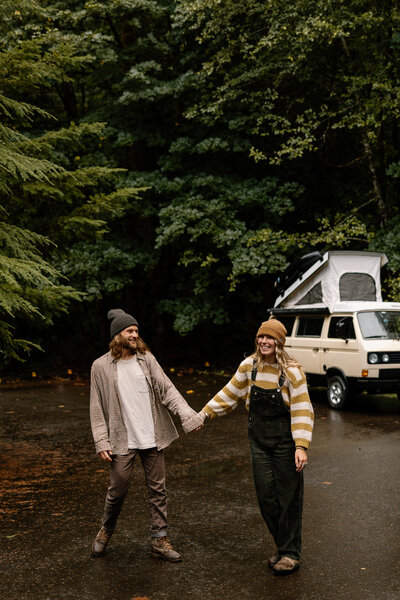 Couple walk hand in hand in front of their van during this oregon lifestyle shoot.