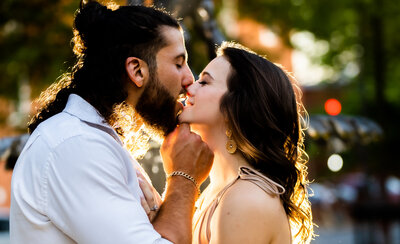 Engaged couple kisses under golden light during shoot with baltimore wedding photographer Kimberly Dean