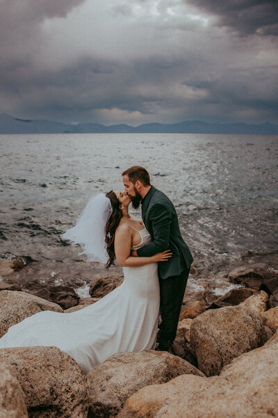 A groom dips and kisses his bride at the gorgeous floral altar.